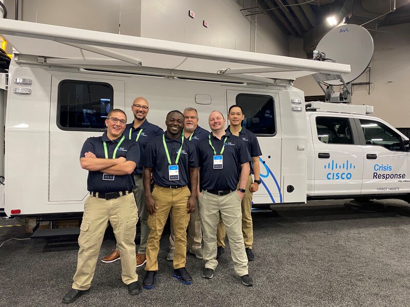 Cisco Crisis Response team members standing in front of large communications vehicle, June 2022.